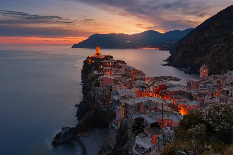 Borgo italiano illuminato al crepuscolo sul mare